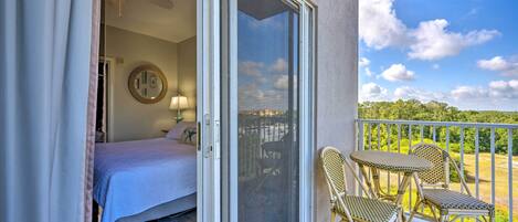 A balcony with a bed, a chair, and a table.