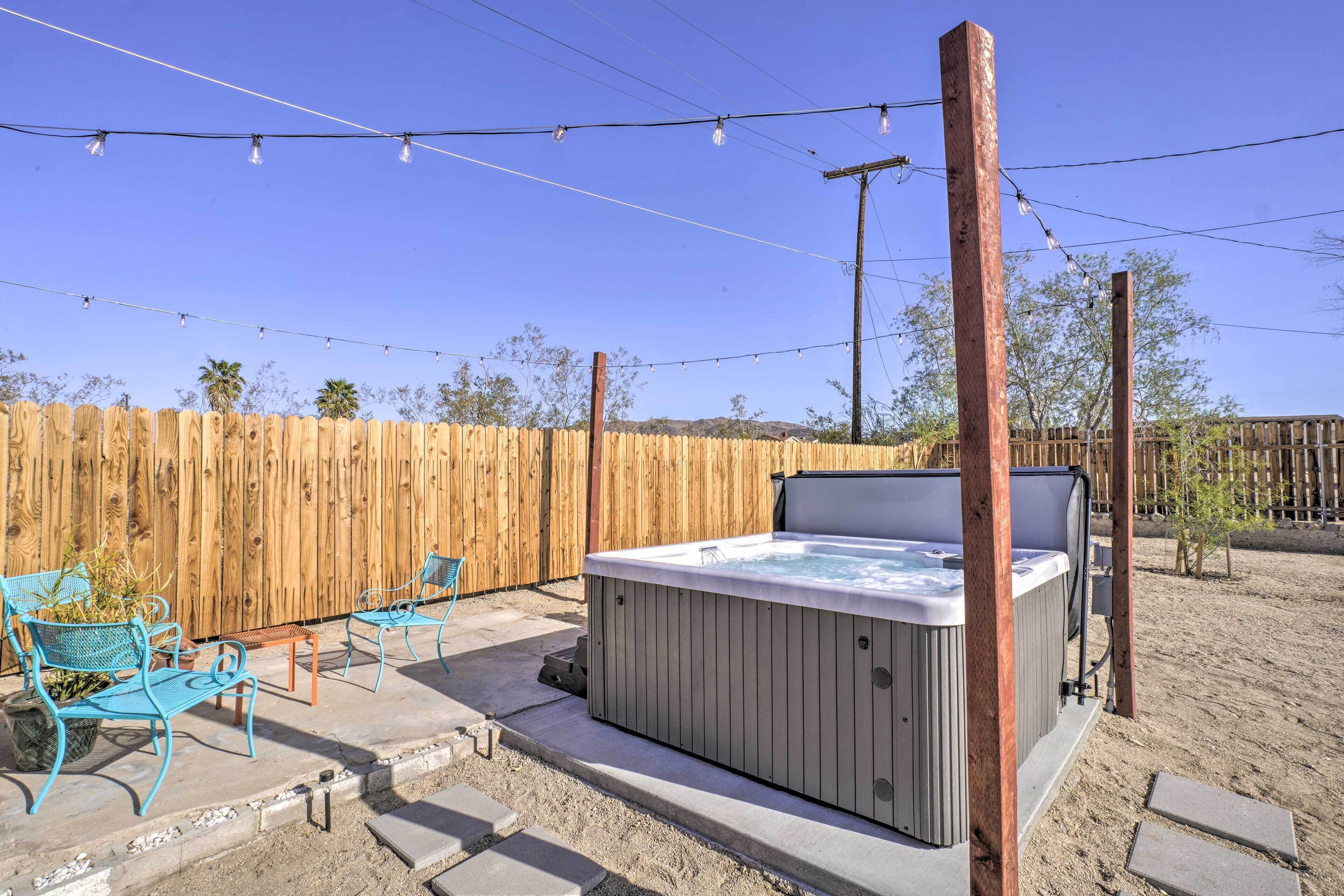 Un jacuzzi con cerramiento de madera y mobiliario exterior.