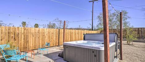 Un jacuzzi con cerramiento de madera y mobiliario exterior.