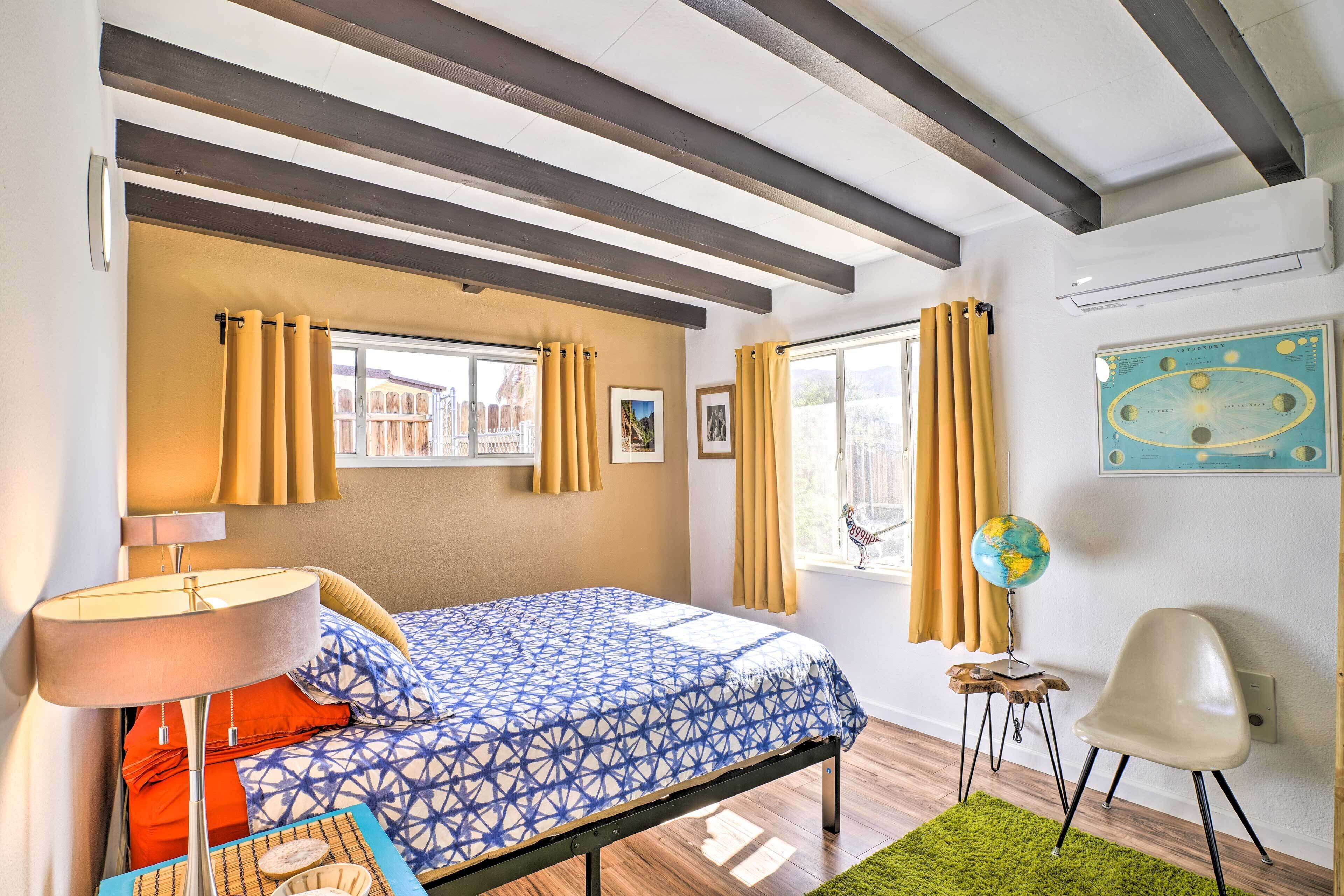 A bedroom with a bed, a lamp, a globe, and a chair.
