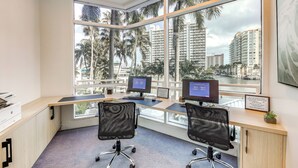 A modern office with two desks, two chairs, and large windows offering a view of palm trees and high-rise buildings. - Modern Ft Lauderdale Condo ~ 7 Mi to Airport! (Fort Lauderdale)