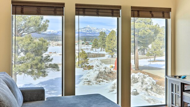 A room with a large window offering a view of a snowy landscape with trees and mountains. - Pagosa Springs Vacation Rental w/ Boat Dock! (Pagosa Springs)