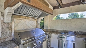 An outdoor kitchen with a stainless steel grill, a built-in oven, and a sink. - Redding Getaway w/ Hot Tub & Outdoor Kitchen! (Redding)
