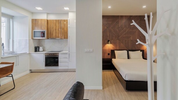 A modern apartment with a kitchen, a dining area, and a bedroom. - Canto Doce Alojamento Troino I (Setúbal)