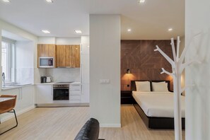 A modern apartment with a kitchen, a dining area, and a bedroom. - Canto Doce Alojamento Troino I (Setúbal)