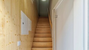 A wooden staircase with a white door at the top. - Canto Doce Alojamento Troino I (Setúbal)