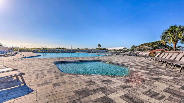 Ein Pool mit Liegestühlen und einer Palme.