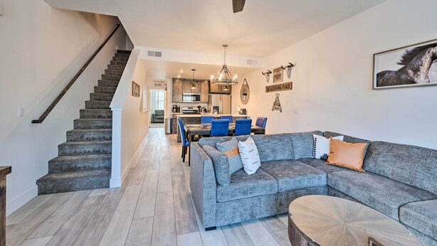 A spacious living room with a gray sectional sofa, a coffee table, and a staircase leading to another level. - Charming Mccall Townhome: Hike, Fish, & Ski! (McCall)