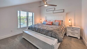 A bedroom with a bed, a ceiling fan, a nightstand, and a window with blinds. - Charming Mccall Townhome: Hike, Fish, & Ski! (McCall)