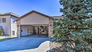 A garage with a stone facade, bicycles, and a small tree in front. - Family-friendly Home w/ Hot Tub: 1 Mi to Dtwn (Estes Park)