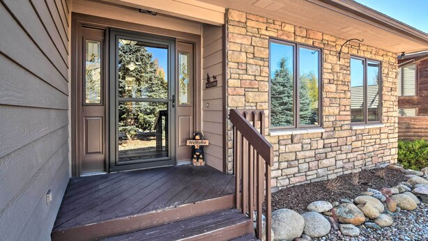 A house with a stone exterior, a wooden deck, and a 'Welcome' sign. - Family-friendly Home w/ Hot Tub: 1 Mi to Dtwn (Estes Park)