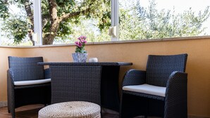 A patio area with wicker furniture, a small table, and a wicker ottoman. - APP ELLY - 2 min from the beach! (Novigrad)