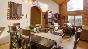 A spacious living room with a wooden ceiling, a dining area with a wooden table and chairs, and a cozy fireplace. - Fairplay Cabin w/ Mountain Views! (Fairplay)