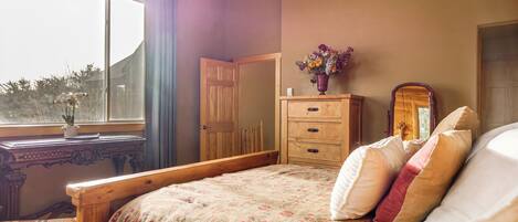 Une chambre à coucher avec un lit, une commode et une fenêtre.