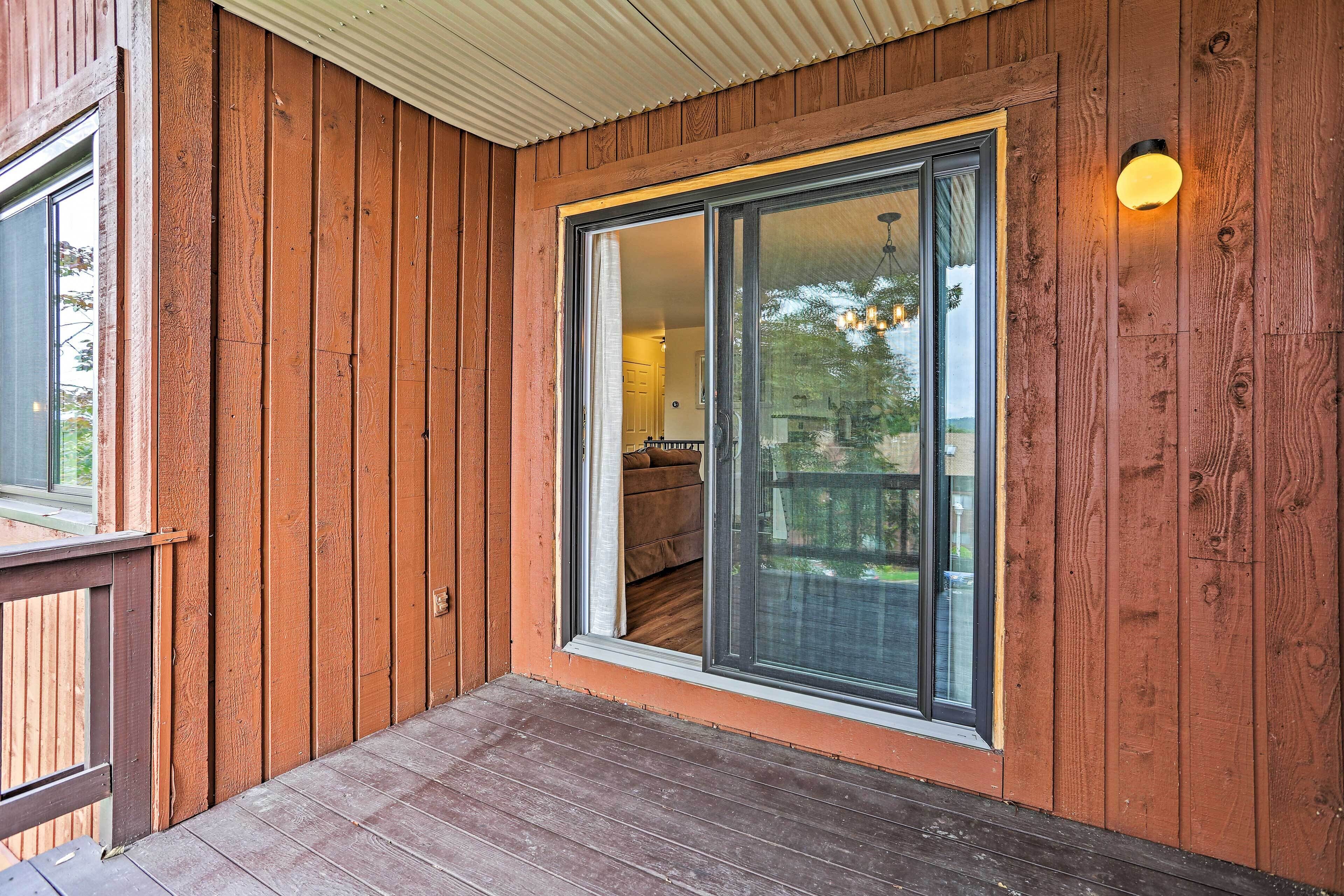 Une façade en bois avec une porte-fenêtre coulissante donnant sur un espace intérieur.
