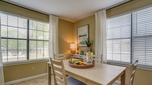 A dining area with a table set for two, a lamp, and a painting on the wall. - Kerrville Vacation Rental Across From River Trail! (Kerrville)
