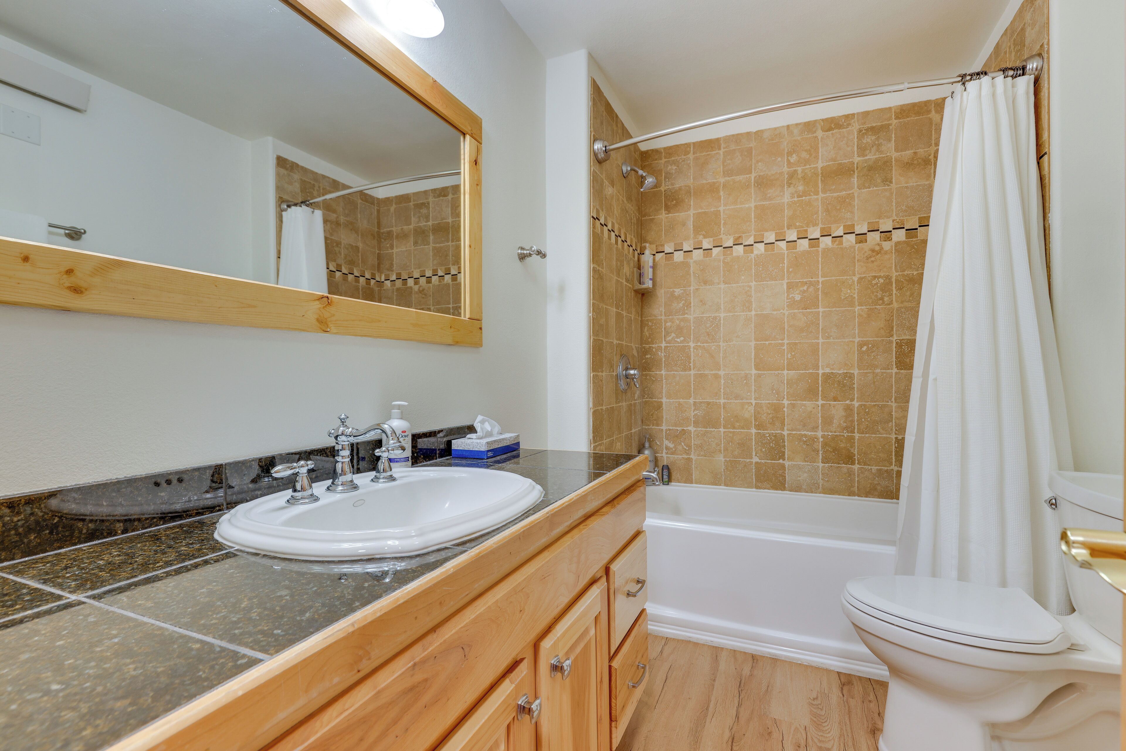 Une salle de bain équipée d’un lavabo, d’un miroir, d’un meuble-lavabo et d’un espace douche.