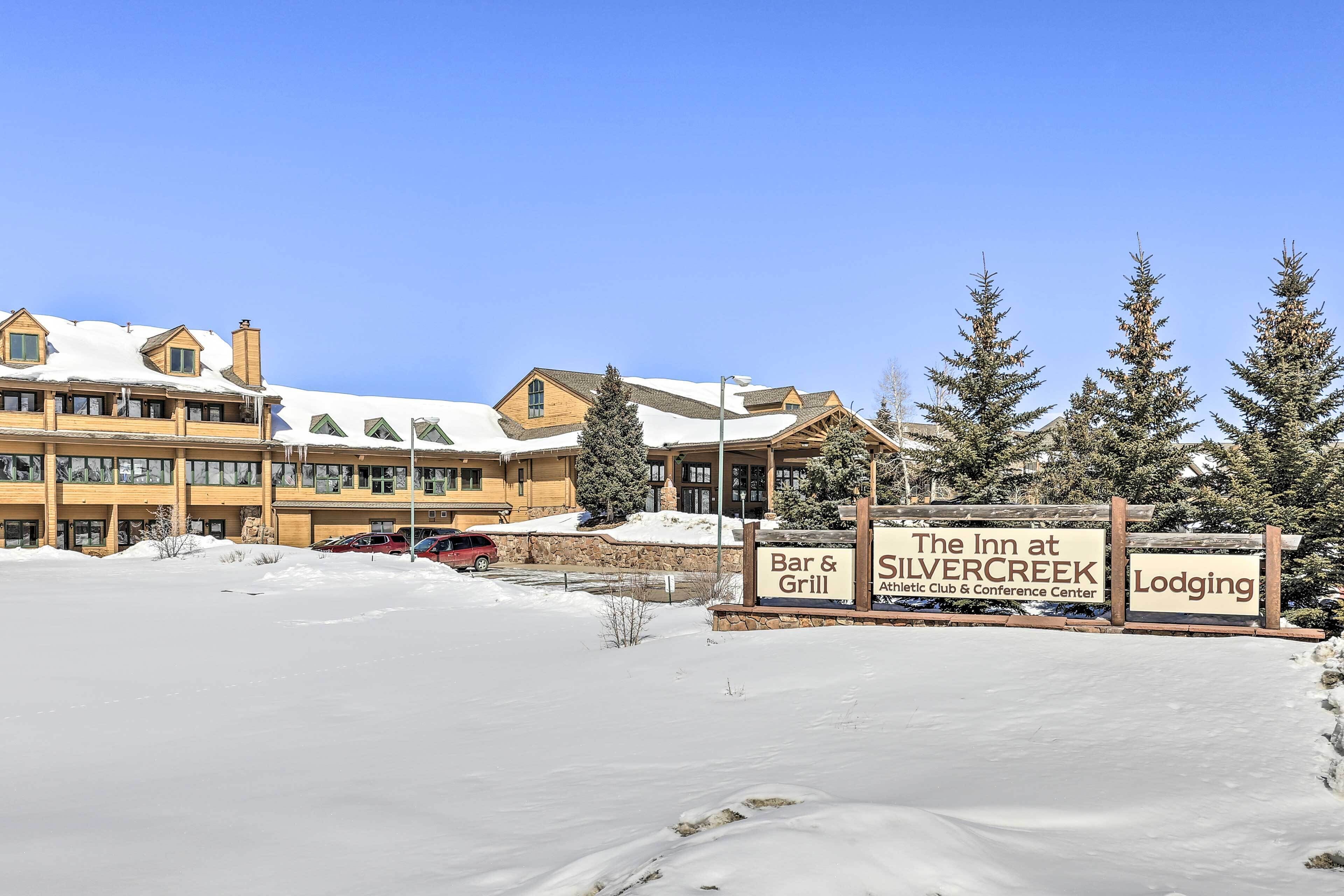 Un espace extérieur enneigé, agrémenté d’un panneau indiquant « The Inn at Silvercreek », qui comprend un bar-grill, un club sportif et un centre de conférences.