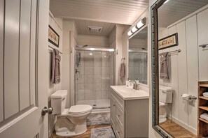 A bathroom with a toilet, sink, and shower. There are towels hanging on the wall and a mirror. - Spacious Cabin - 4 Mi to Blue Ridge Parkway! (Boone)