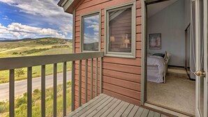 A room with a bed, a door, and a window. - Mtn View Granby Condo w/ In-unit Hot Tub! (Granby)
