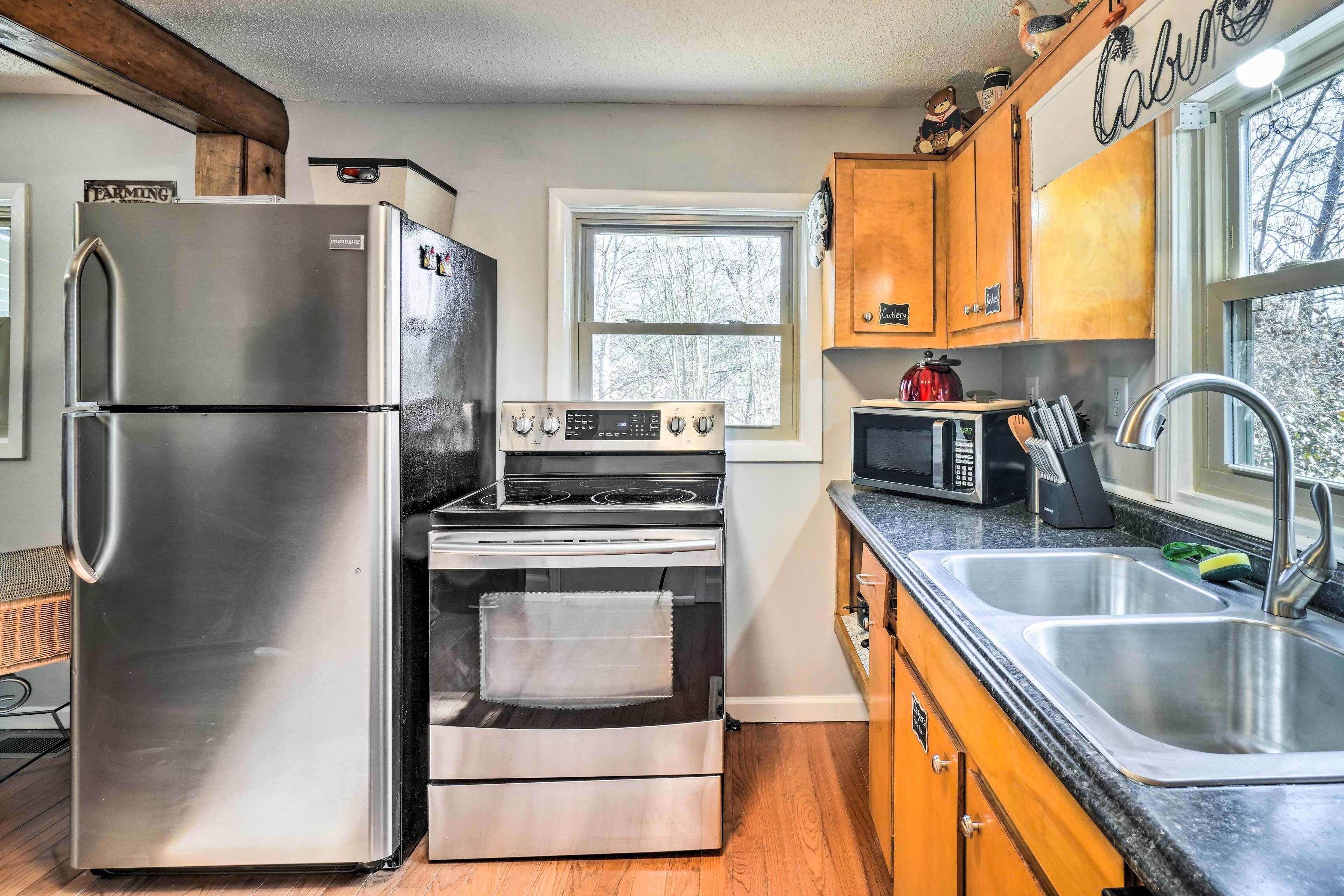 A kitchen with a stainless steel refrigerator, a built-in oven, a microwave, and wooden cabinets.