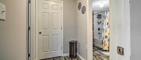 A hallway with a wooden floor, a white door, and a small table.