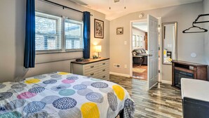 Une chambre à coucher avec un lit, une commode et une fenêtre avec des rideaux.