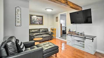 Relax in this stylish living room with a black leather sofa, wooden coffee table, and flat-screen TV.