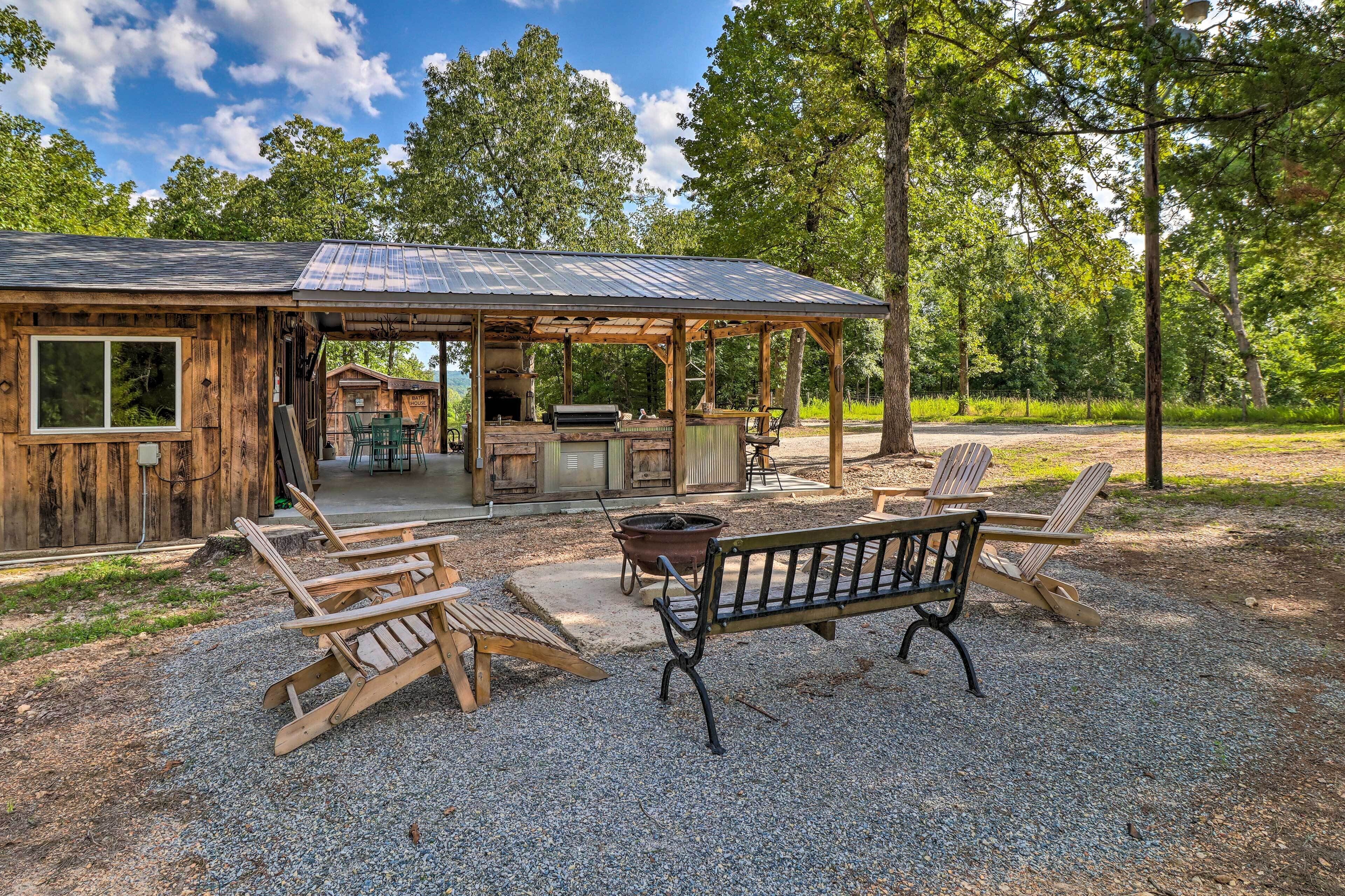 A rustic cabin with a covered patio, outdoor seating, and a barbecue area.