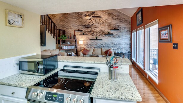 A kitchen with a microwave, stove, and granite countertop. - Boat Slip Access: North Padre Island Condo! (Corpus Christi)