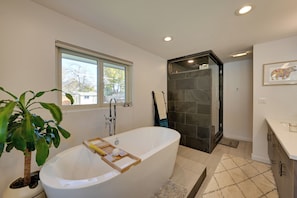 A modern bathroom with a freestanding bathtub, a shower enclosure, and a window providing natural light. - < 7 Mi to Dtwn: Denver Home w/ Large Yard! (Denver)