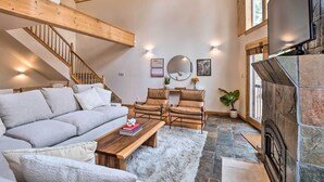 A spacious living room with a high ceiling, a fireplace, a sofa, two armchairs, a coffee table, and a staircase. - 2 Mi to Dtwn: Leadville Haven w/ 2 Furnished Decks (Leadville)