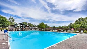 A rectangular swimming pool with a clear blue water surface, surrounded by a paved deck and lounge chairs. - Branson Retreat w/ Pool Access ~ 3 Mi to Dtwn (Branson)