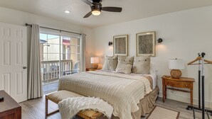 A bedroom with a bed, bedside tables, a ceiling fan, and a view through a sliding door. - South Padre Island Getaway - Newly Renovated! (South Padre Island)