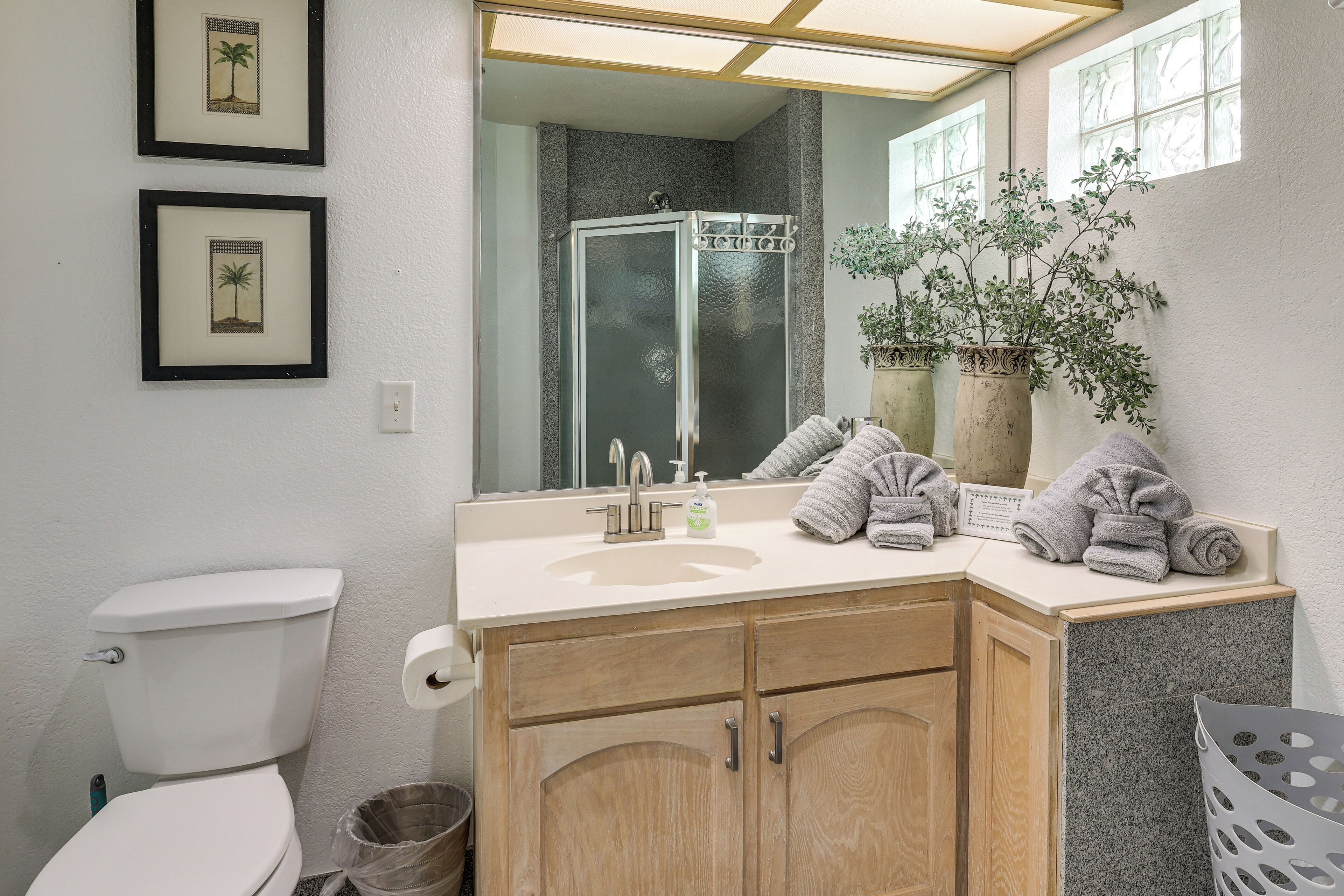 Ein Badezimmer mit Toilette, Waschbecken, Spiegel und Dusche.