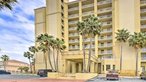 A multi-story hotel with balconies, palm trees, and a parking area. - Sunny SPI Las Villas Condo w/ Resort Amenities! (South Padre Island)