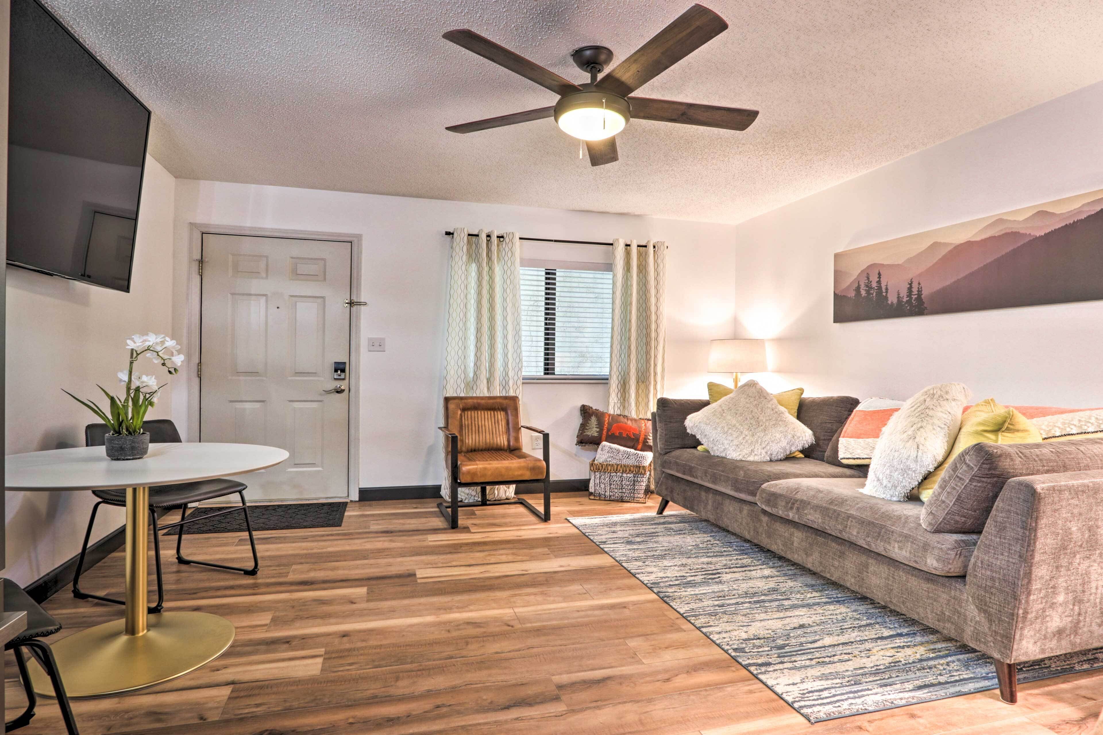 A living room with a ceiling fan, a sofa, a coffee table, and a chair.