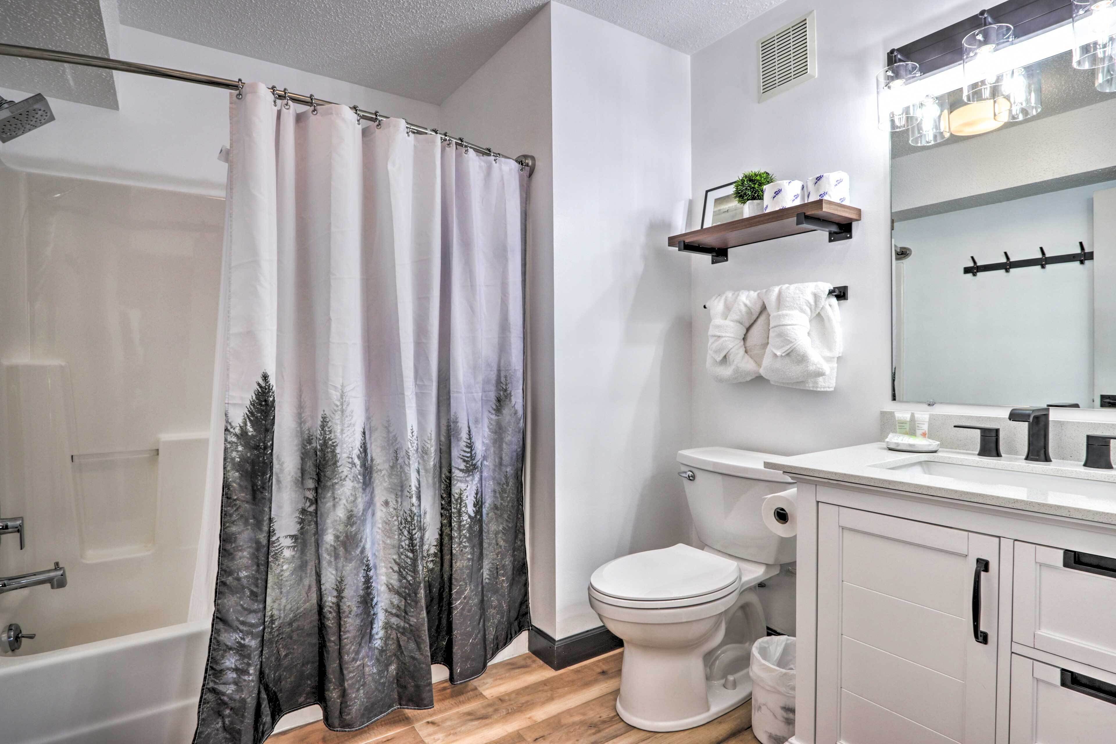 A bathroom with a shower, toilet, and sink.