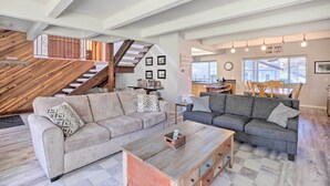A spacious living area with two sofas, a coffee table, and a staircase. - Pet-friendly Rockaway Beach Home w/ Fire Pit! (Rockaway Beach)