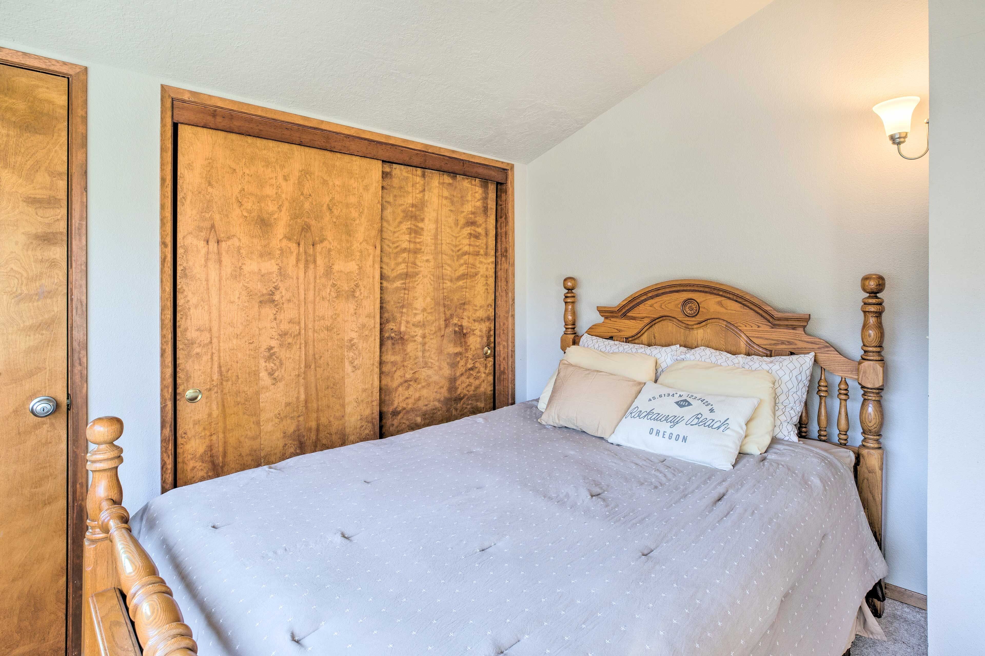 Ein Schlafzimmer mit einem hölzernen Bett, einem großen Kleiderschrank und einer Wandleuchte.