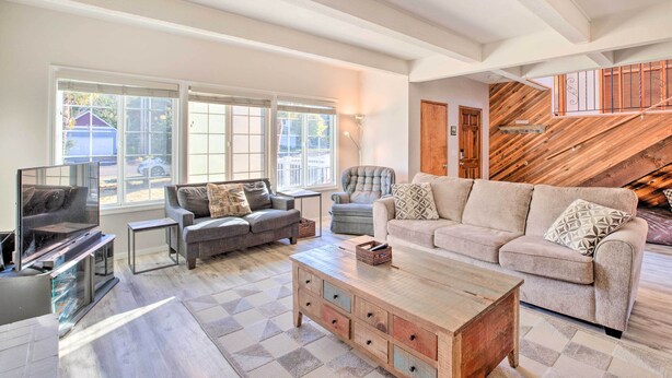 A spacious living room with a large window, a wooden coffee table, and two sofas. - Pet-friendly Rockaway Beach Home w/ Fire Pit! (Rockaway Beach)