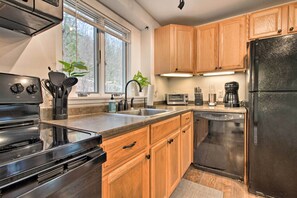 A modern kitchen with wooden cabinets, a stainless steel refrigerator, a microwave, and a dishwasher. - Cozy Killington Retreat ~ 5 Mi to Ski Resort (Killington)