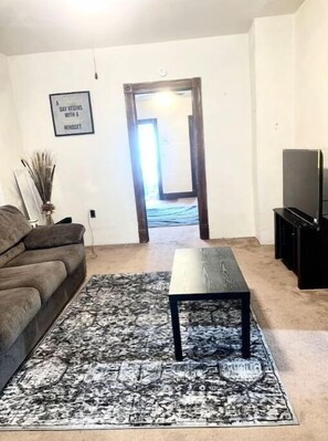 Relax in this inviting living room with a sofa, coffee table, and entertainment unit.
