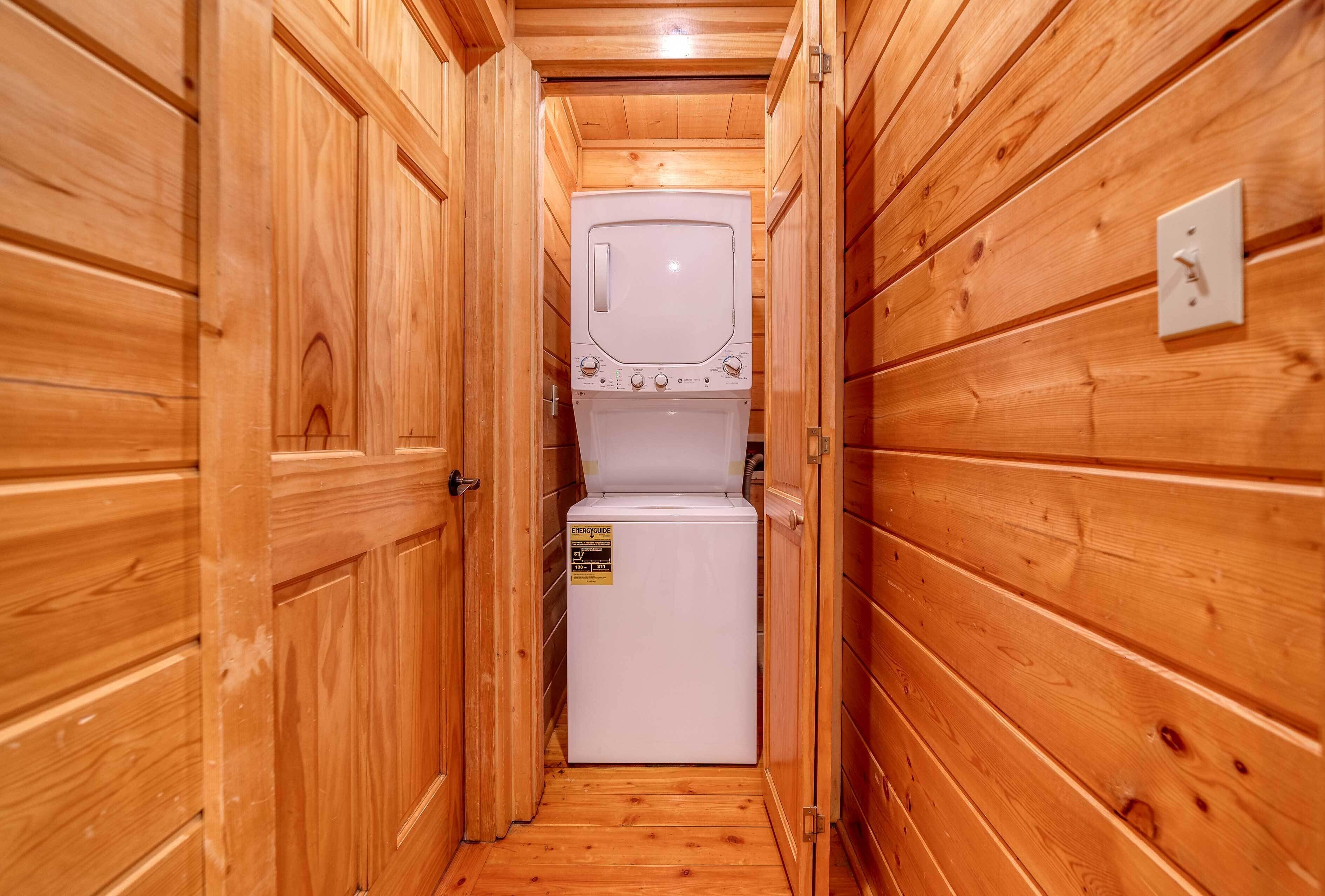 A narrow wooden hallway with a white washing machine in the center.