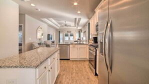 A modern kitchen with granite countertops, stainless steel appliances, and white cabinetry. - Walk to Shore: 'oyster House' Port St Joe Getaway (Port St. Joe)