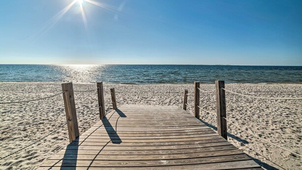 A wooden boardwalk leading to a sandy beach with a clear blue sky and the sun shining. - Walk to Shore: 'oyster House' Port St Joe Getaway (Port St. Joe)