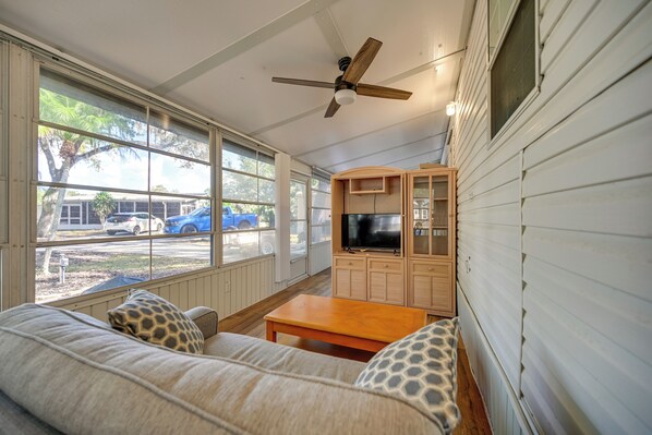 Relax on the enclosed porch with a sofa and TV, taking in the view of the outside.
