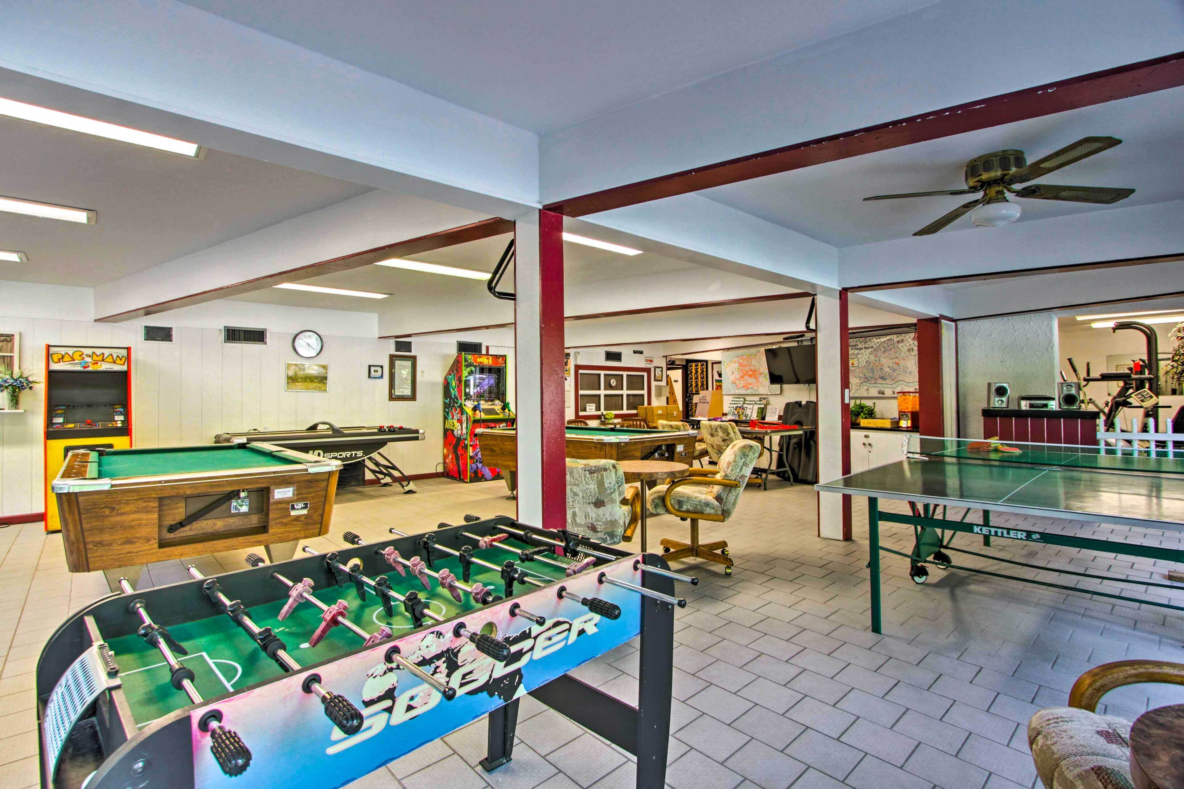 A spacious indoor area with a foosball table, pool table, and ping pong table.