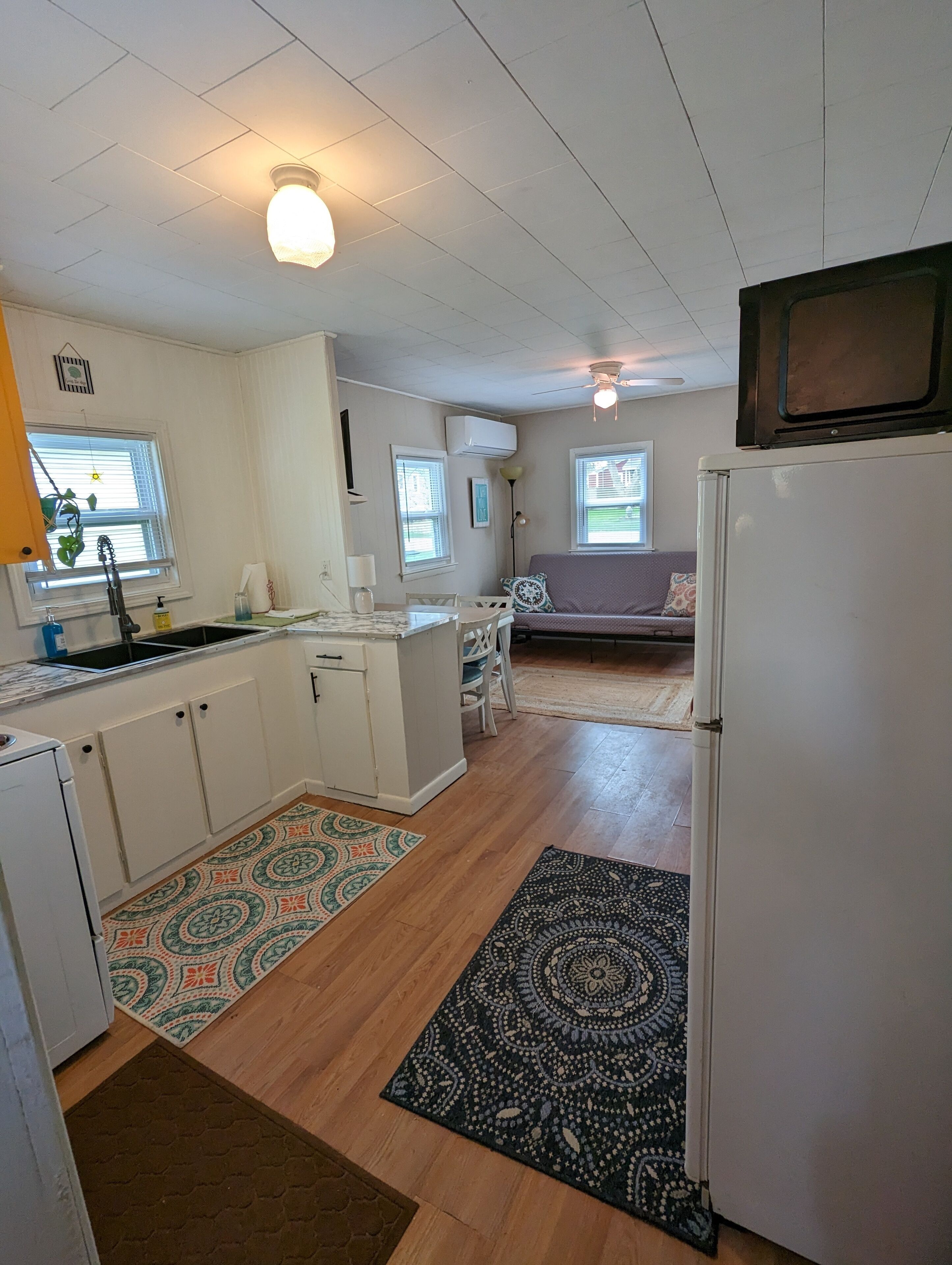 A compact kitchen with a refrigerator, sink, and dining area.