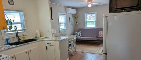 A compact kitchen with a refrigerator, sink, and dining area.